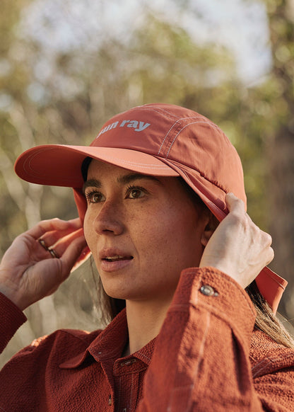 Person wearing an orange UPF50+ sun protection legionnaire hat