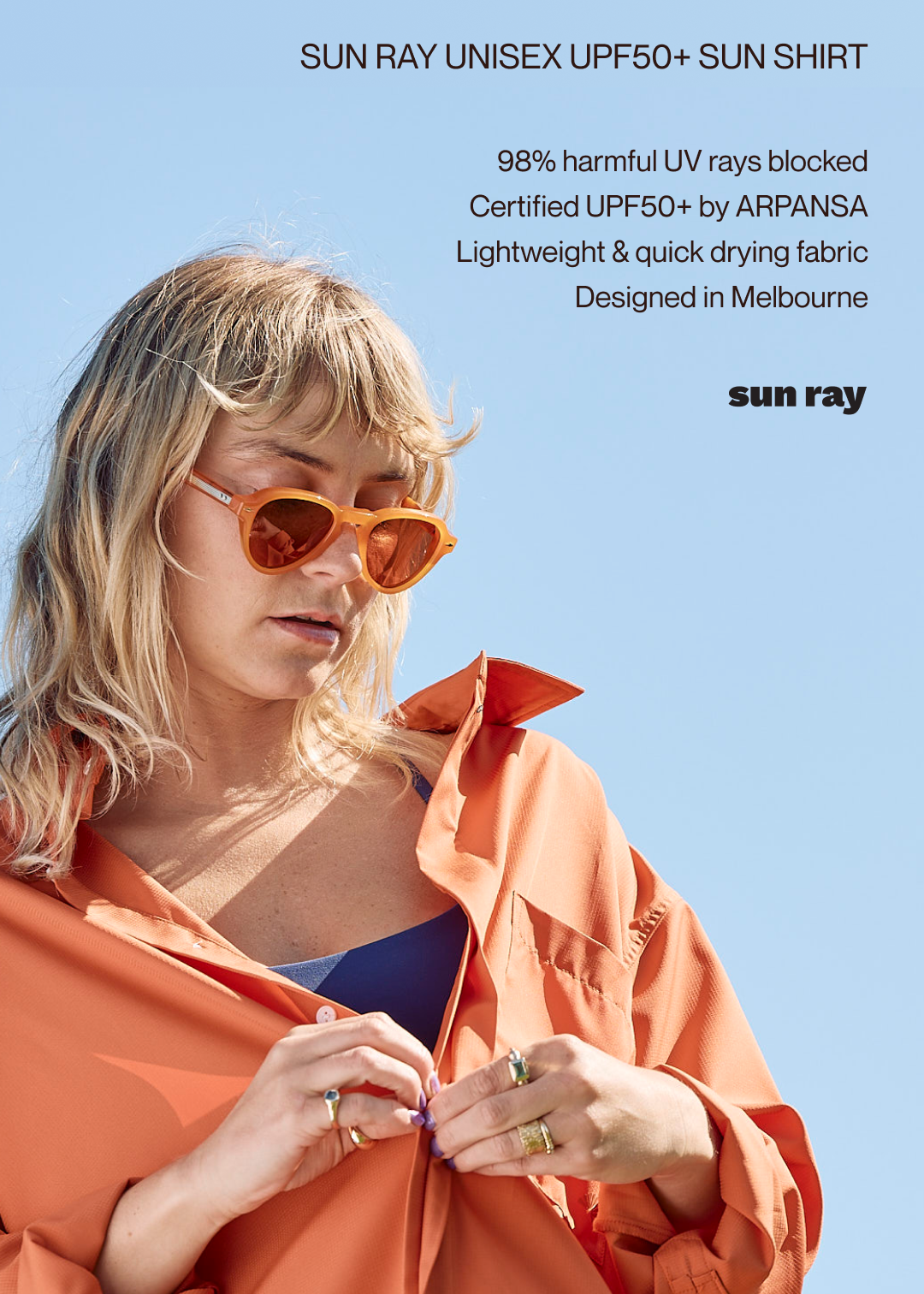 A woman wearing a burnt orange sun ray unisex UPF50+ sun shirt and orange sunglasses.